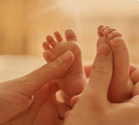 Mutter massiert die Füßchen ihres Babys